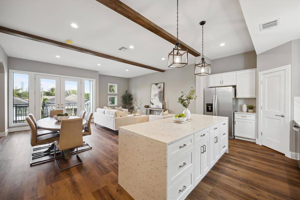 Seamlessly connected to the living and dining areas, the kitchen features matching luxury vinyl flooring and a waterfall-edge island—ideal for meal prep, casual dining, or gathering with friends and family.