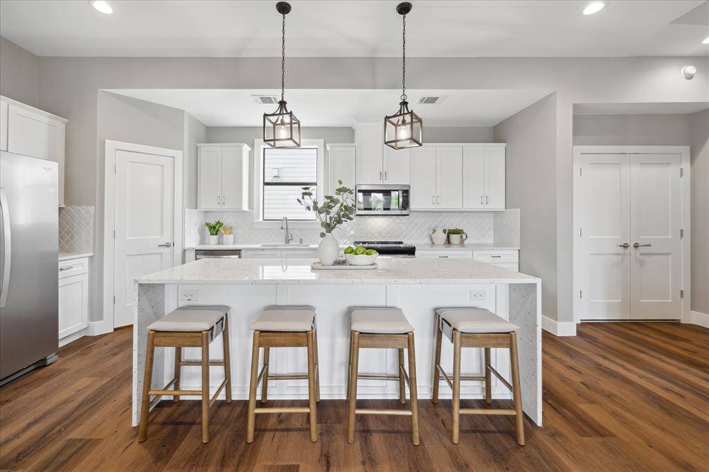 Designed for real life, this kitchen offers both beauty and practicality with a walk-in pantry to the left and laundry closet just steps away—keeping everything within easy reach while preserving the clean, open layout.