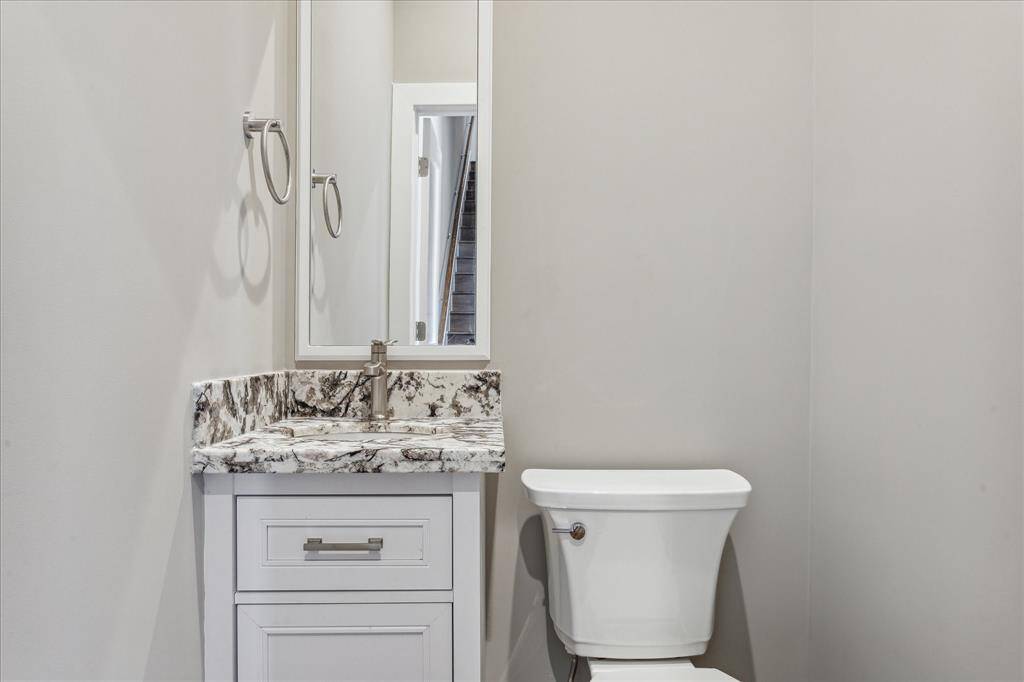 Conveniently tucked away on the main living level, this half bath features a stylish granite vanity and modern fixtures—perfect for guests without sacrificing space or design.