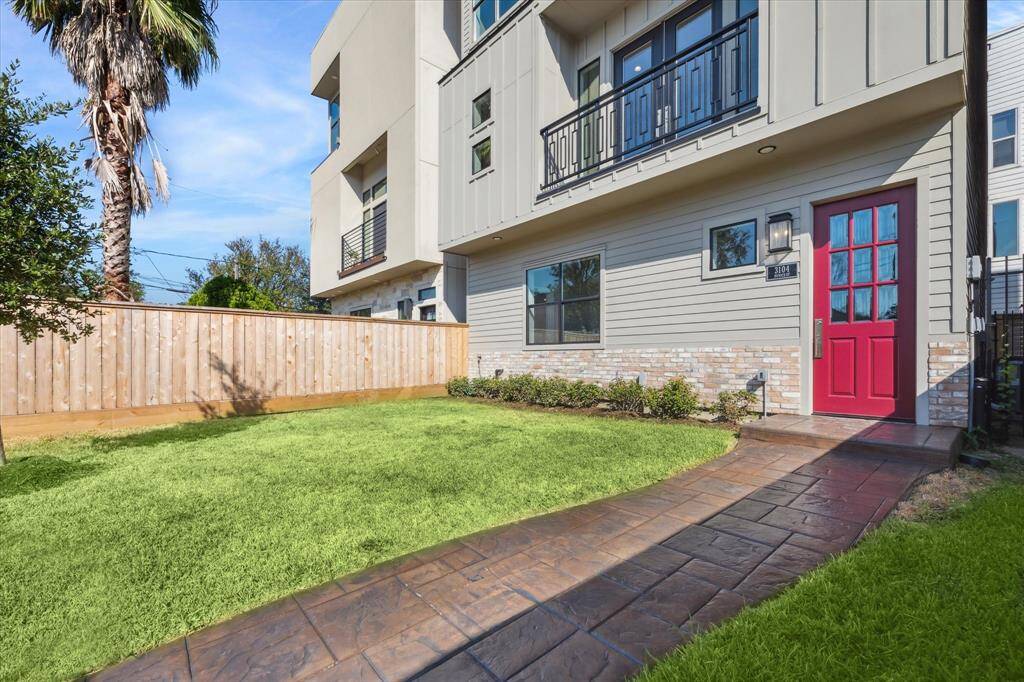 Spacious and fully fenced, the front yard offers a rare private green space—perfect for morning coffee, pets at play, or casual entertaining. A charming red door and stamped concrete path welcome you home in style.