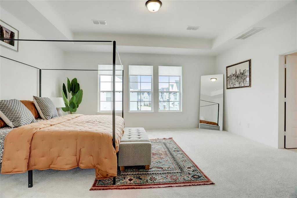 The second-floor primary suite offers size, privacy, and incredible natural light.