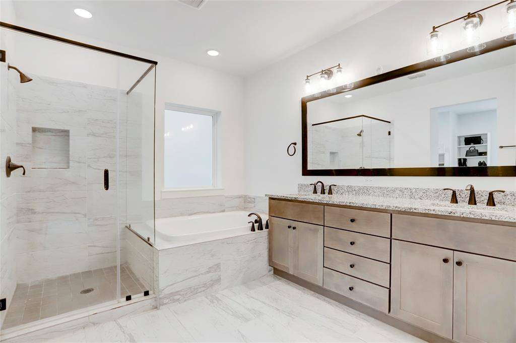 The light and bright primary bathroom offers dual vanities, soaker tub, separate shower, and water closet.