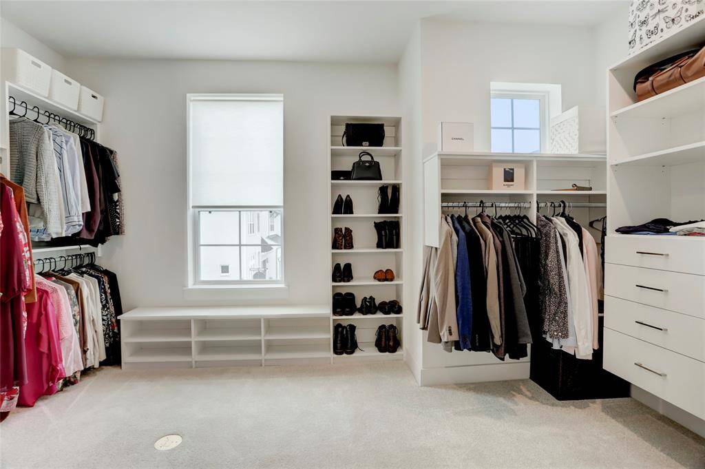 Through the primary bathroom sits the oversized closet with natural light, built-in storage, and space (and electrical plug) for a closet island.