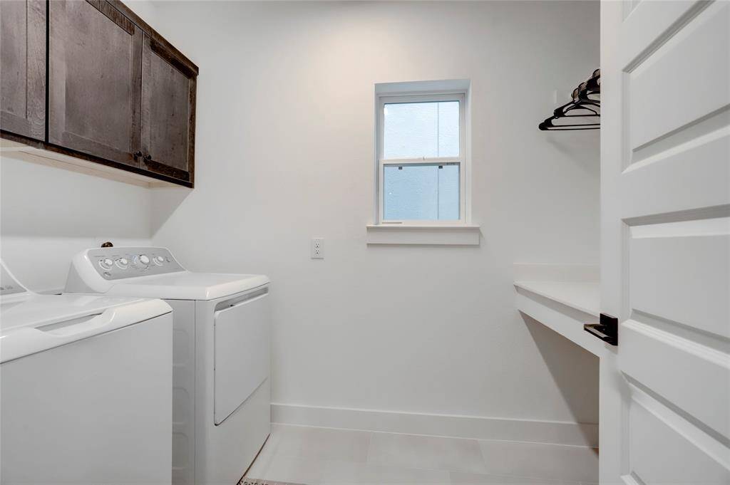 The utility room rounds out the second floor and allows space for full-sized appliances, cabinets, hanging space, and a room length folding table.