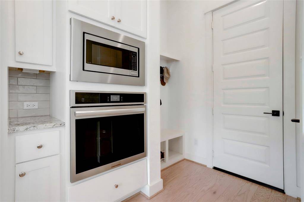 The space between the fridge and garage sits the second oven, microwave, drop zone, coffee counter, and pantry.