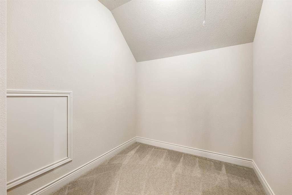 Versatile room located off the gameroom upstairs is a carpeted room with sloped ceilings and neutral walls, ideal for storage, a small office space or a craft room.
