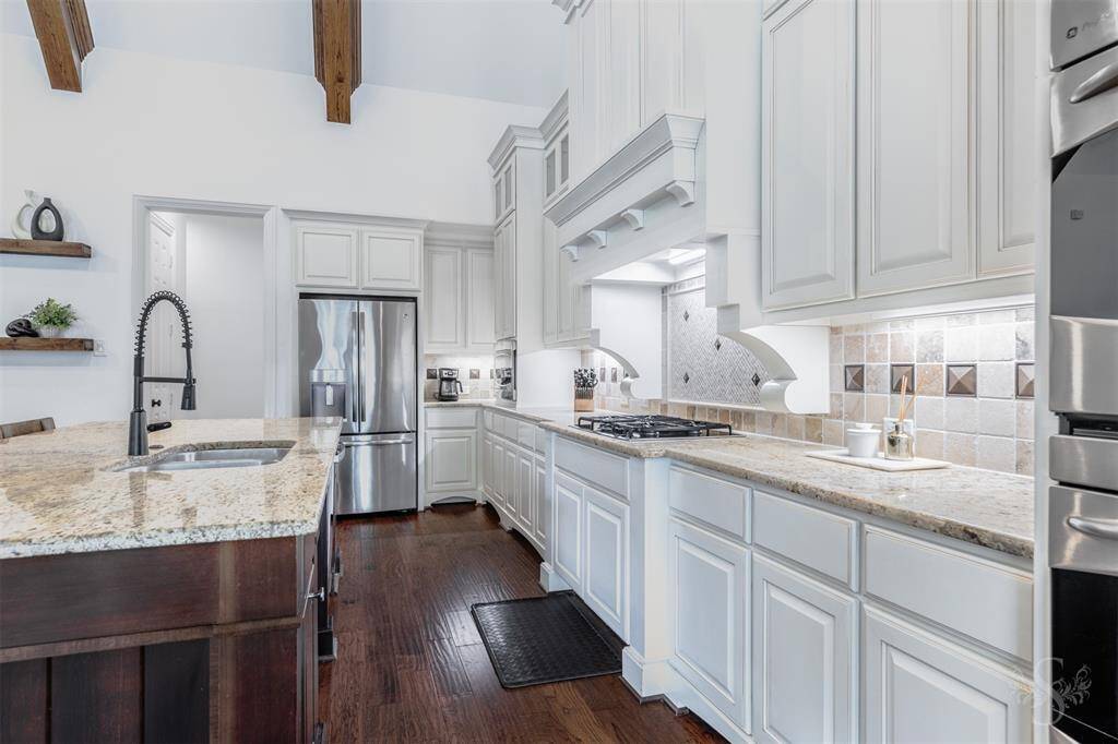 Gas cook top, custom hood vent, double oven, walk-in pantry and under mount lighting; all these details aspire convenience in mind.