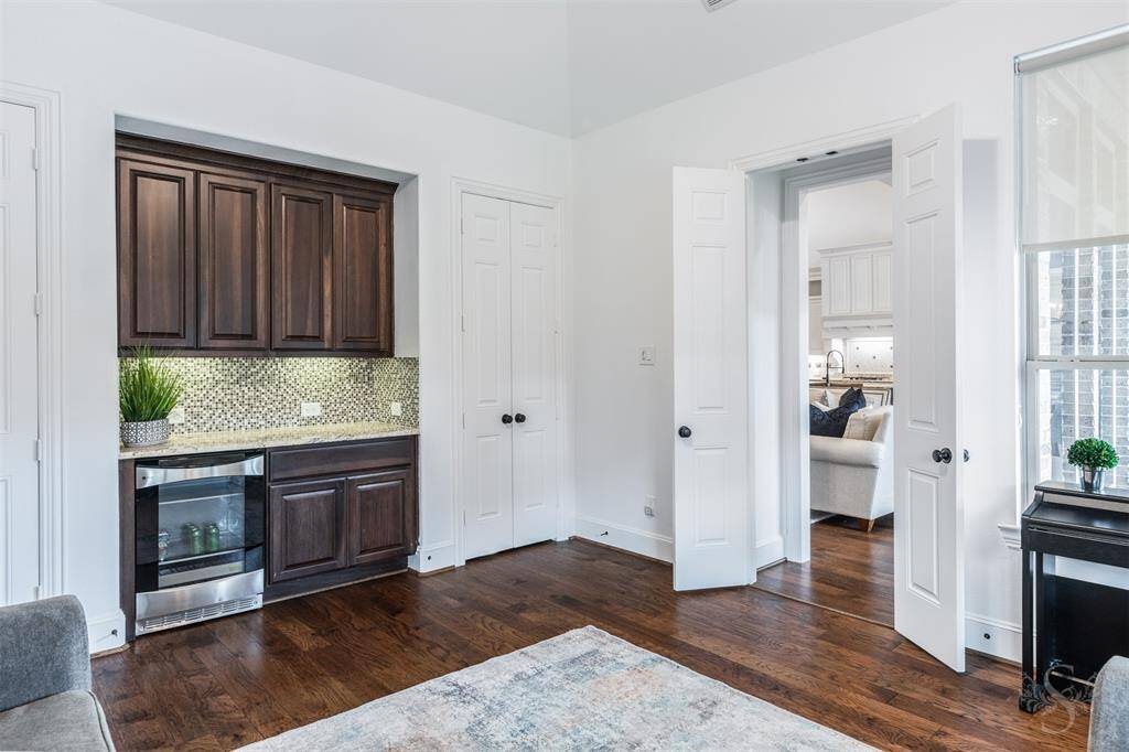 This inviting game room also features a stylish wet bar with refrigerator and sleek cabinetry and back splash—perfect for entertaining. This room is magnificent!