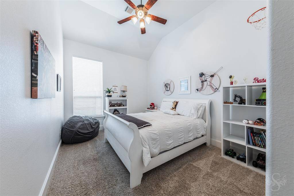 This is one of three secondary bedrooms. All secondary bedrooms offer high ceiling with a ceiling fan, neutral paint and carpeted flooring.