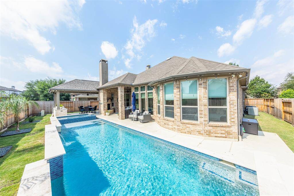 The pool and spa are beautifully designed with a sun shelf and a sheer descent waterfall.