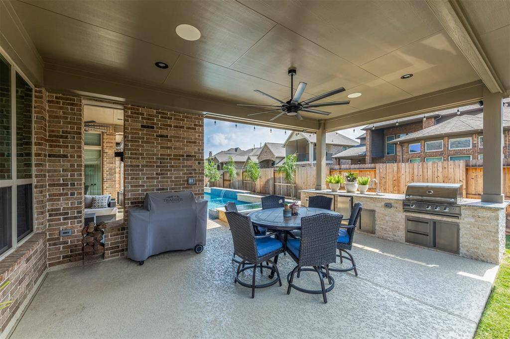 Experience the perfect outdoor oasis with a spacious covered patio, complete with a built-in grill, sink, refrigerator, ice machine, dining area, and a view of the sparkling pool. Ideal for entertaining and relaxation.