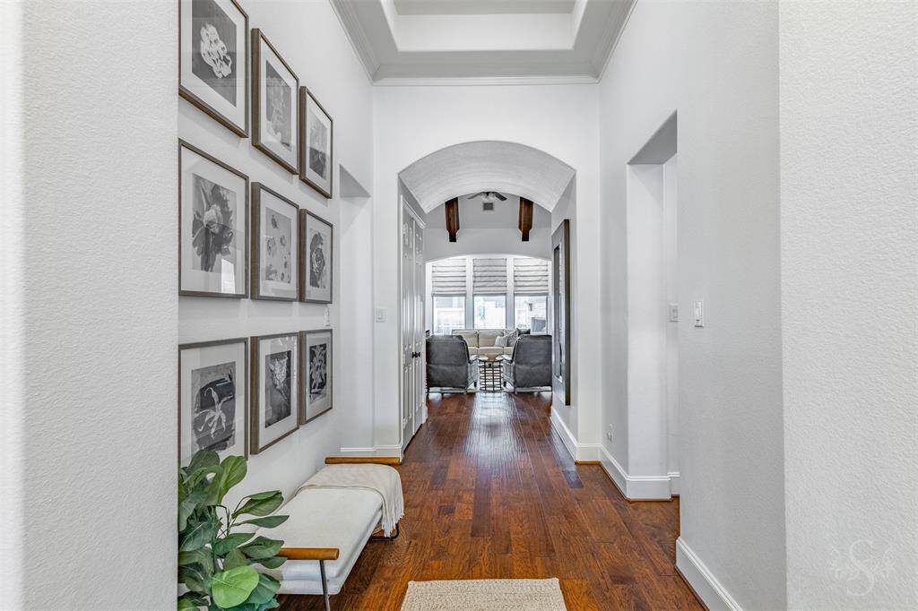 As you walk through the front door, you will step into the light-filled foyer. You will immediately notice the wide hallway, high ceilings and rich wood flooring that is present throughout the home.