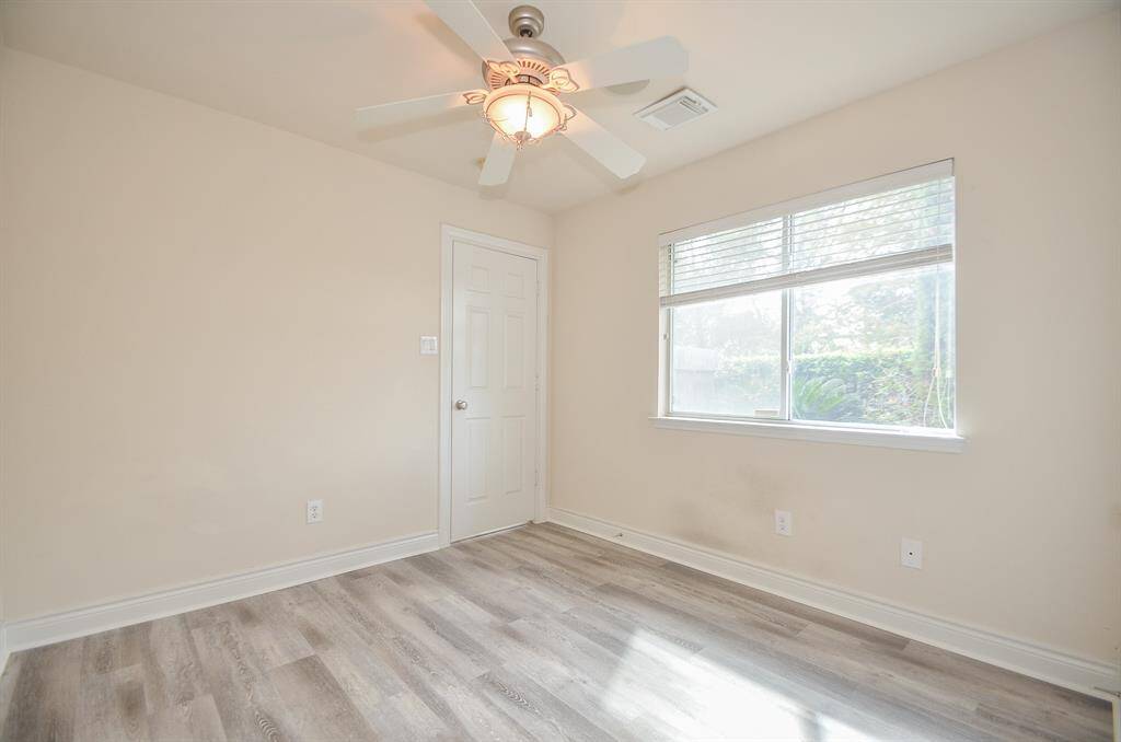 First Floor bedroom with new waterproof luxury vinyl plank - overlooking back yard.