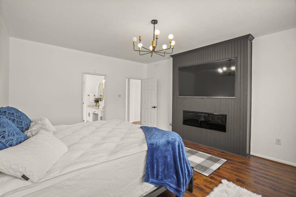 Luxurious downstairs primary suite featuring an electric fireplace and large screen TV for ultimate comfort and entertainment.