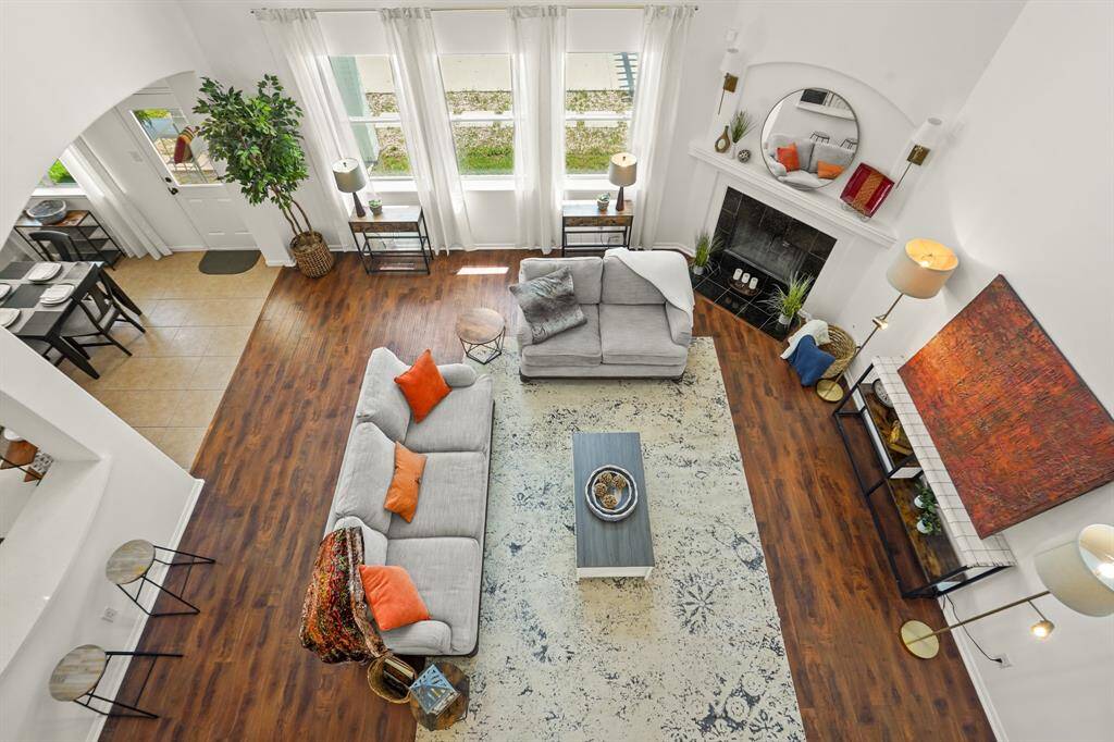 Spacious and inviting family room with abundant natural light, cozy fireplace, and elegant hardwood floors, perfect for relaxation and gatherings.