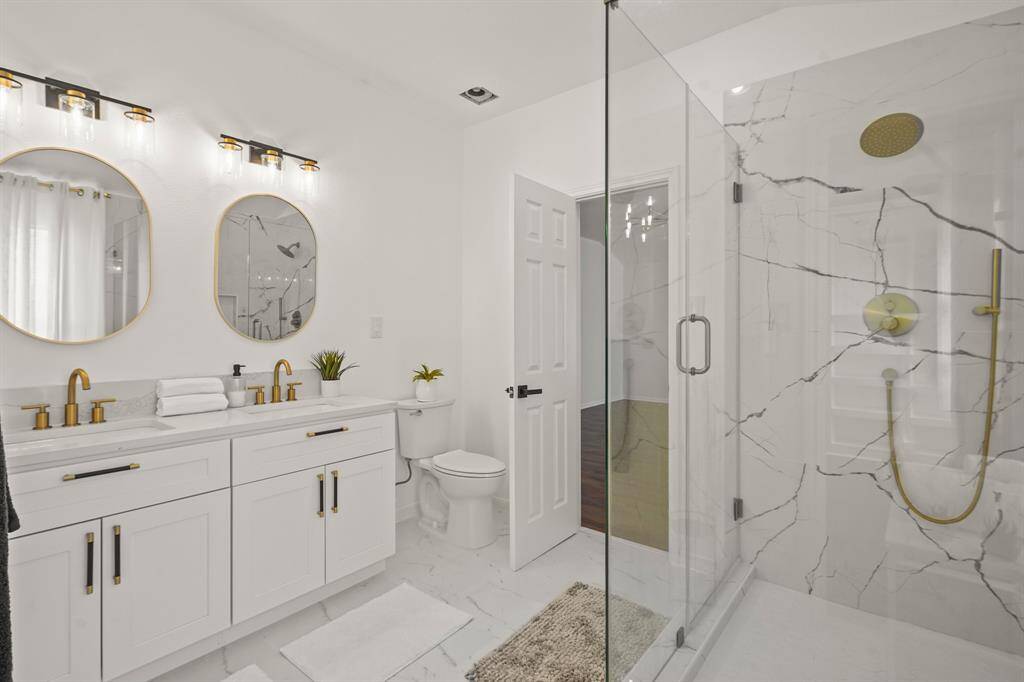 Discover the beautifully remodeled upstairs primary ensuite, featuring a spacious walk-in shower and an expansive closet with custom built-ins.