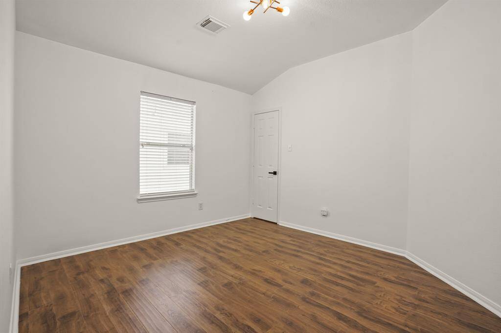Cozy fourth bedroom featuring elegant hardwood floors and ample natural light. Perfect for a guest room or home office.