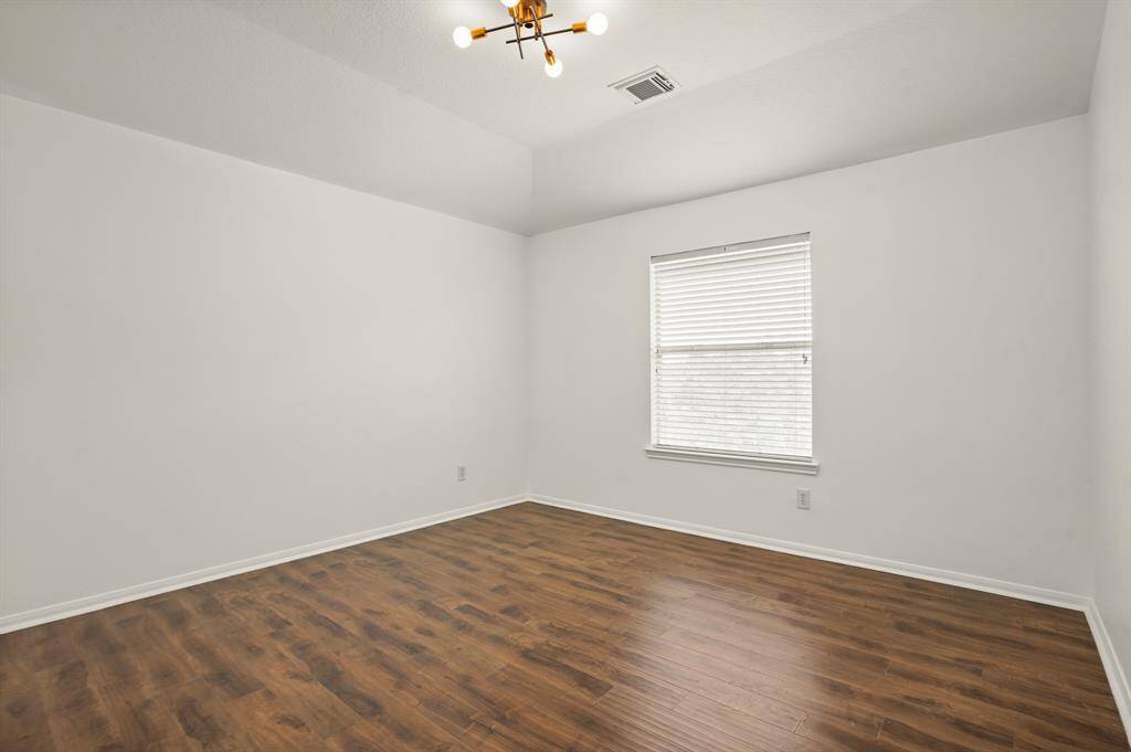 Spacious and bright, this versatile bedroom features sleek hardwood floors and ample natural light—perfect for a cozy guest room or home office.