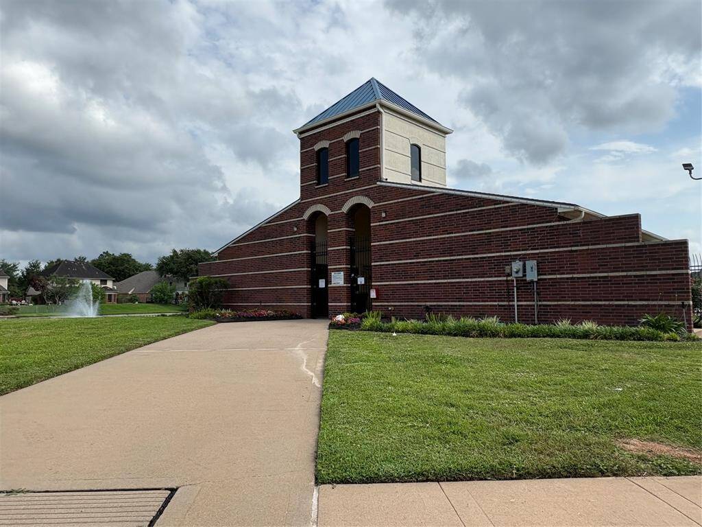 Experience community living with this inviting clubhouse, featuring a striking brick façade and surrounded by lush landscaping. Perfect for social gatherings and relaxation.