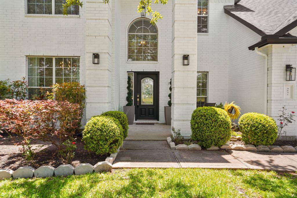 Elegant front entry with charming landscaping and a welcoming door.