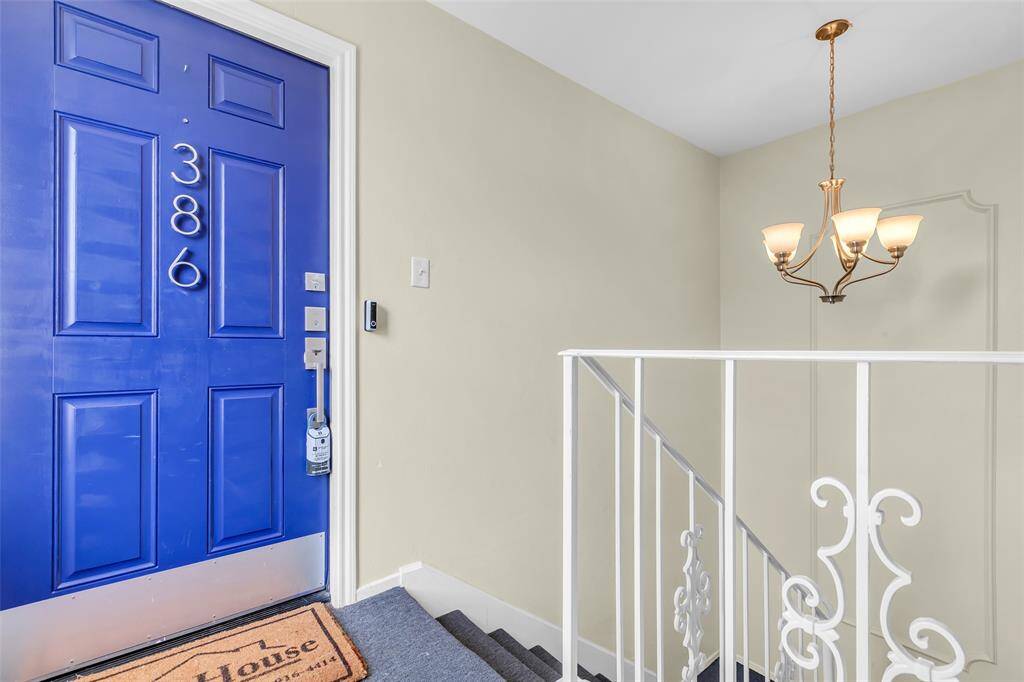 Step into unit 386 through a bold, updated blue front door. Located on the upper level of a quiet, interior hallway, this entrance is both private and secure, with upgraded lighting and an elegant staircase chandelier.
