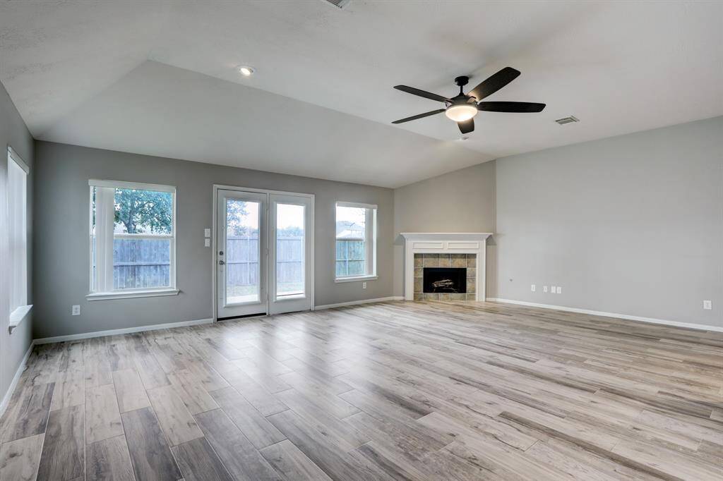 The large family room has a new ceiling fan, gas fireplace and french doors leading to the fenced backyard...