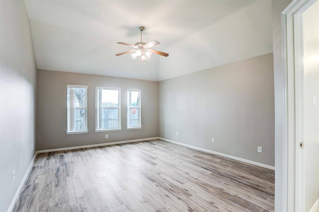 The primary bedroom offers a peaceful retreat at the rear of the home, featuring ample natural light and a spacious layout.