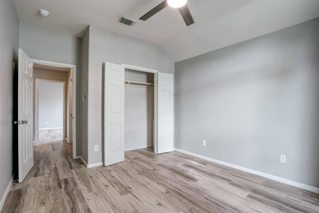 Discover comfort and style in Bedroom 2 with wood-look flooring, a ceiling fan, and generous closet space.