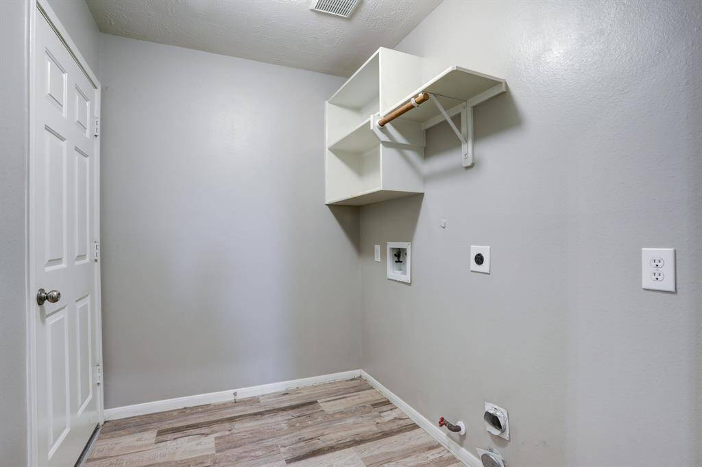 Convenient utility room with gas and electric hookups, leading to the garage and an extra enclosed space.