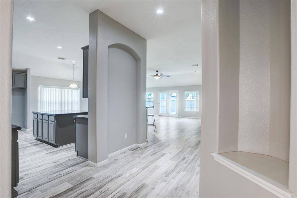 The hallway opens to a spacious kitchen and bright family room.