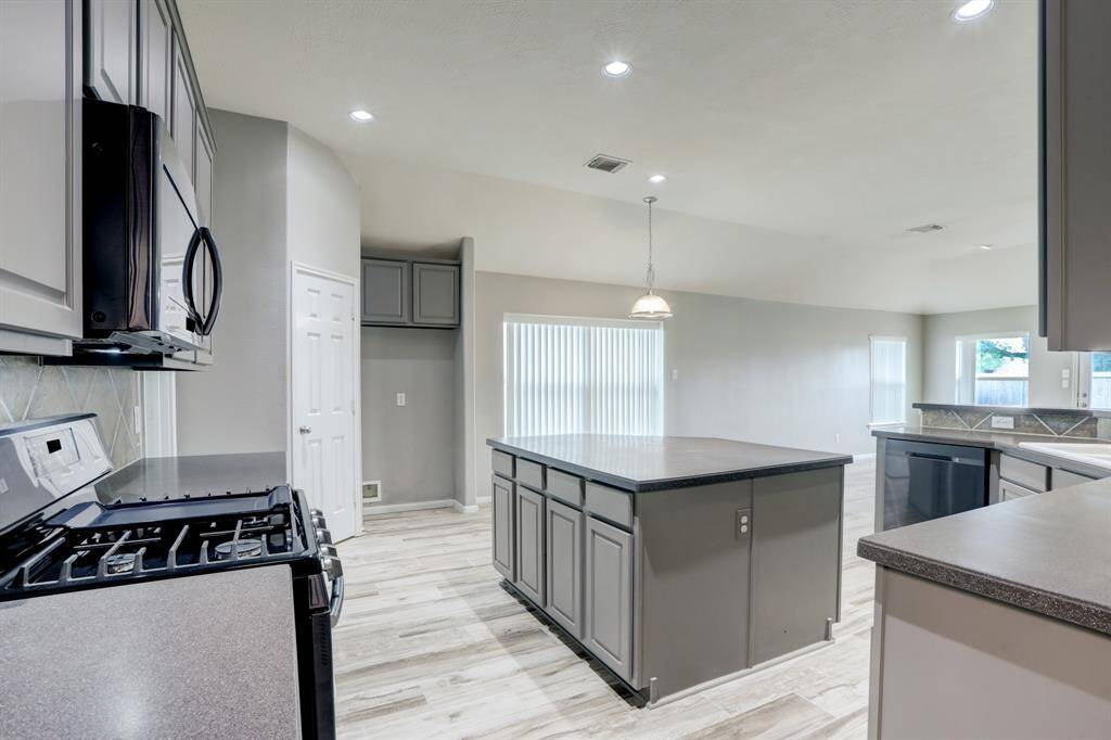 Spacious kitchen featuring abundant granite countertops and ample cabinetry.