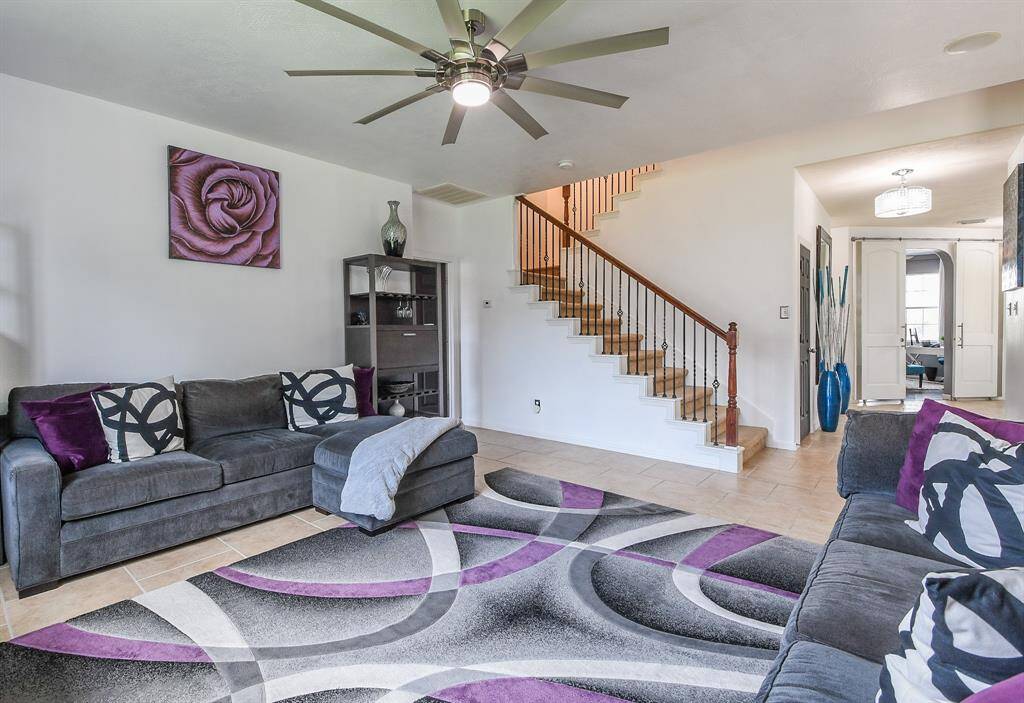 A high ceiling is embraced by a good looking contemporary ceiling fan,while the living area is bathed in pure natural light.