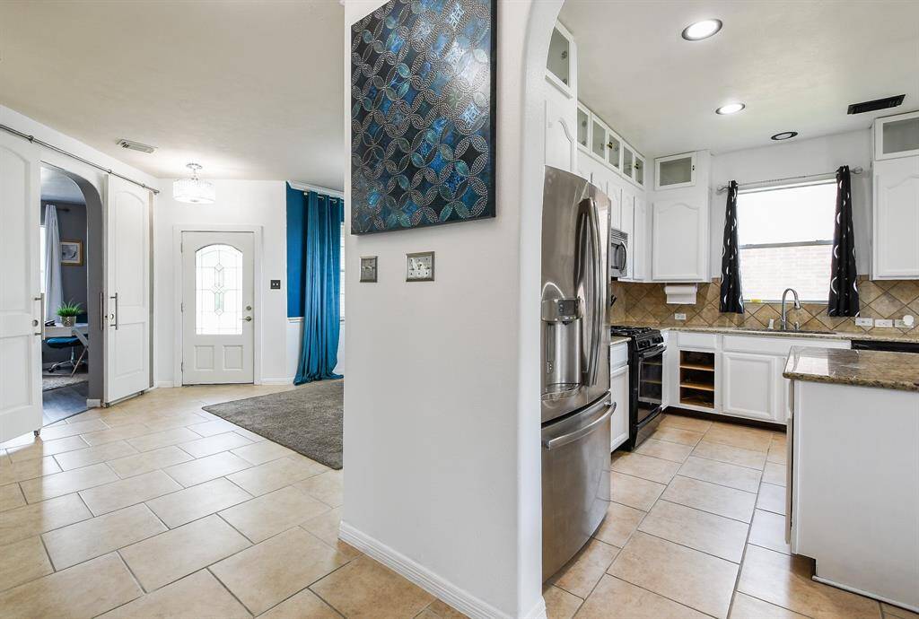 This is your favorite cook's dream kitchen, for sure! There's just something about primarily white kitchens, that seem to instantly warm us! Tremendous space is filled with custom cabinetry, up and down; creamy granite counter tops and good looking tile backsplash.