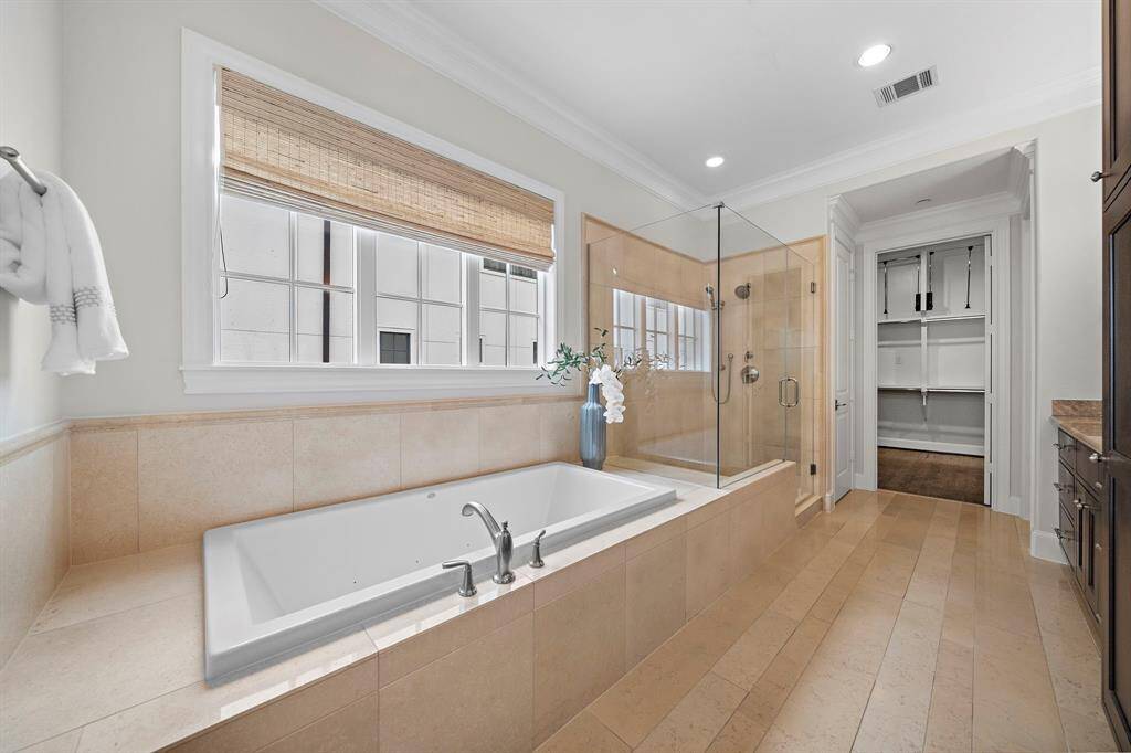 Unwind in spa-inspired luxury with a deep jetted soaking tub and a frameless walk-in glass shower, accentuated by elegant tilework and designer fixtures. Direct access to an expansive walk-in closet and dual vanities makes this primary ensuite as functional as it is serene, delivering a true high-end retreat.