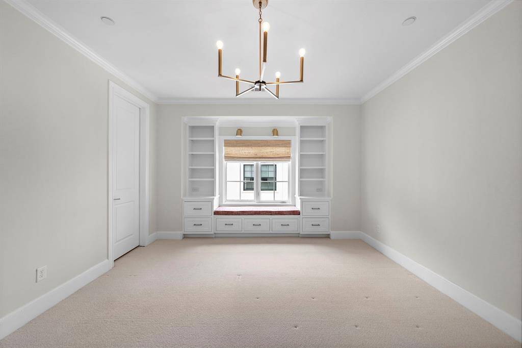 Distinctive secondary bedroom features a custom window seat flanked by built-in shelving and generous drawer storage—perfect for relaxing with a book or displaying your favorite décor.