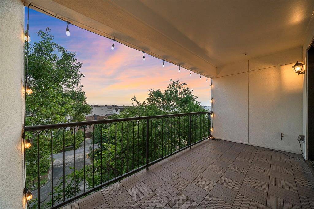 This spacious covered balcony offers stunning city views and is finished with elegant iron railings and stylish tile flooring. Ambient string lights create an inviting outdoor oasis, while a gas connection and privacy with no back neighbors make it ideal for gatherings or quiet moments above the treetops.