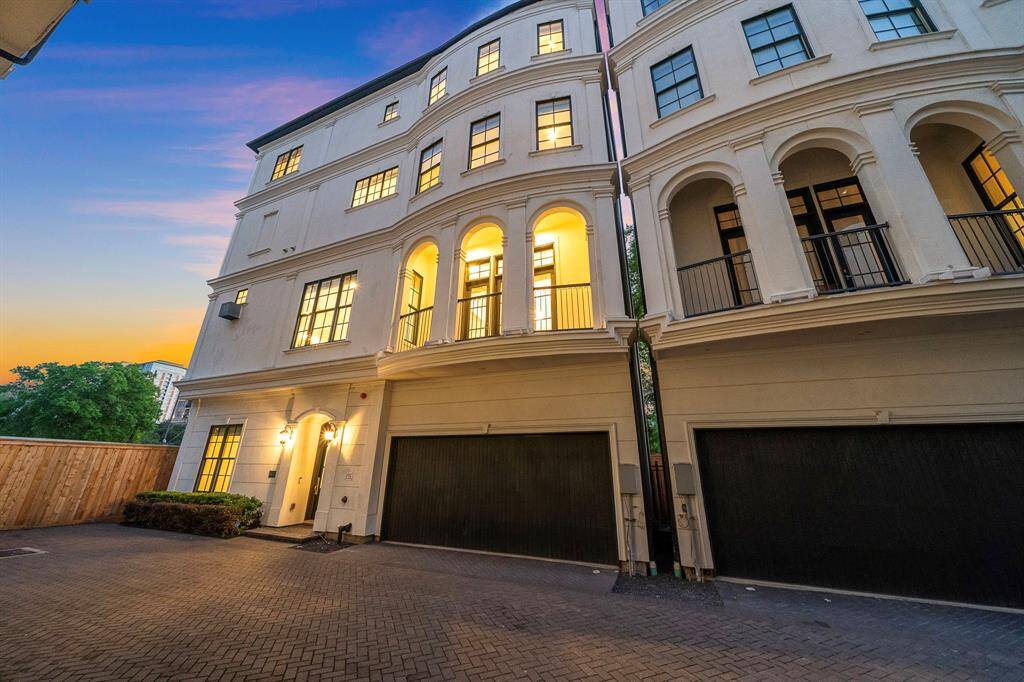 Elegant stucco exterior is highlighted by grand arches and multiple balconies, offering elevated architectural distinction on this prominent corner unit.