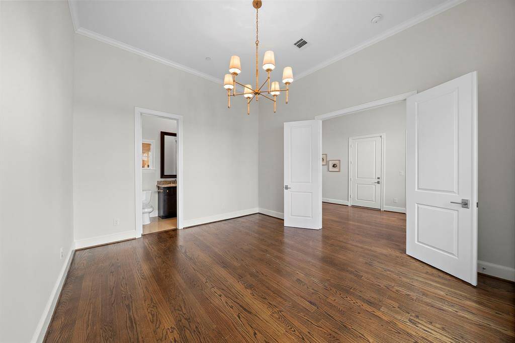 Versatile secondary suite features soaring ceilings, elegant hardwood floors, and an updated designer chandelier. Ensuite bath with granite vanity and double-door access delivers privacy and flexibility, ideal for a guest retreat, home office, or creative flex space within this luxury residence.