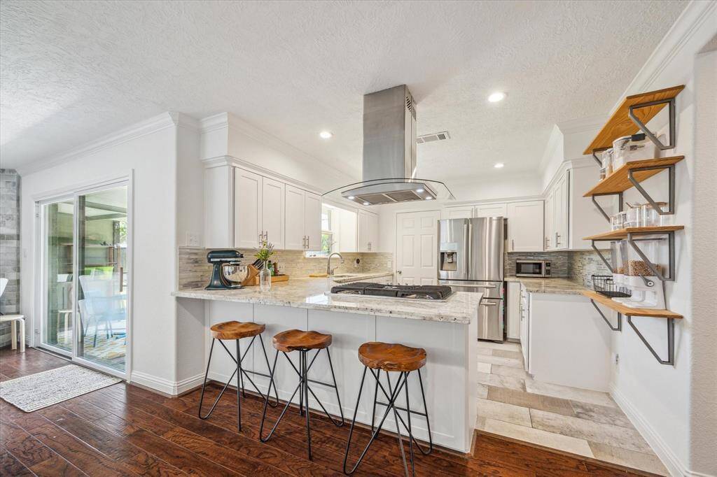 View looking into the home's kitchen area. Granite countertop peninsula with room for 3 bar stools.