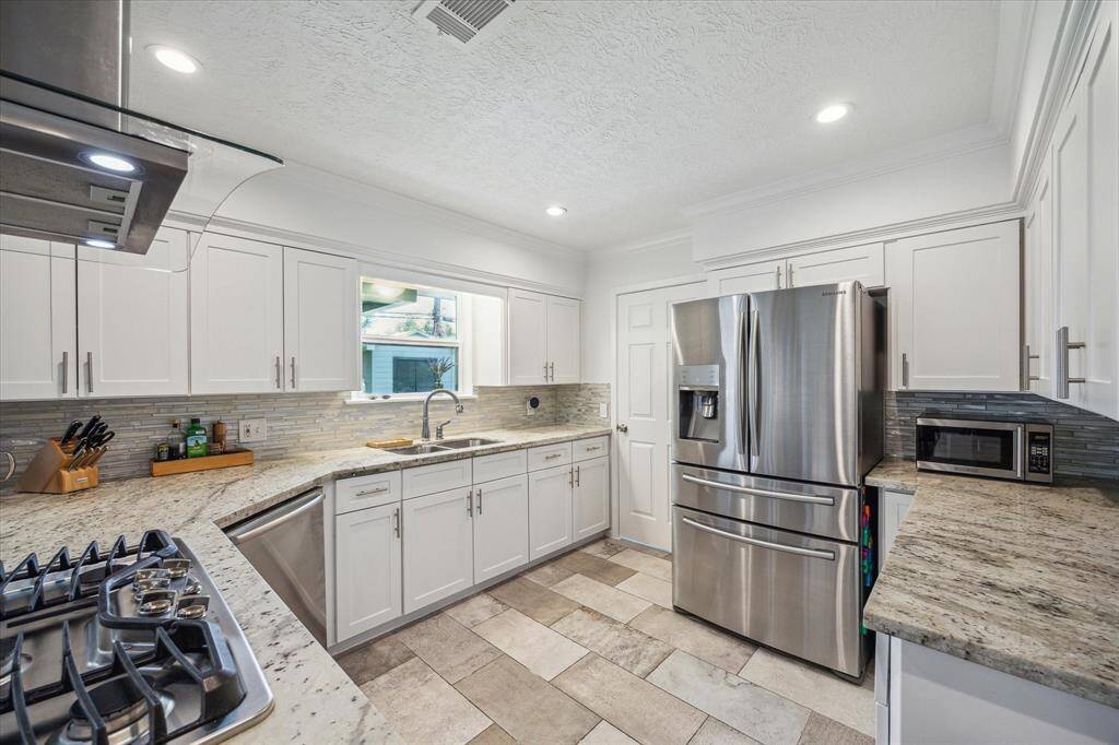 The window above the kitchen sink has a direct view of the home's backyard area so the cook and the cleaner can watch the kids and pets play while working away.  The door to the left of the kitchen refrigerator opens to the homes dedicated utility room with access directly into the homes 2 car oversized attached garage.