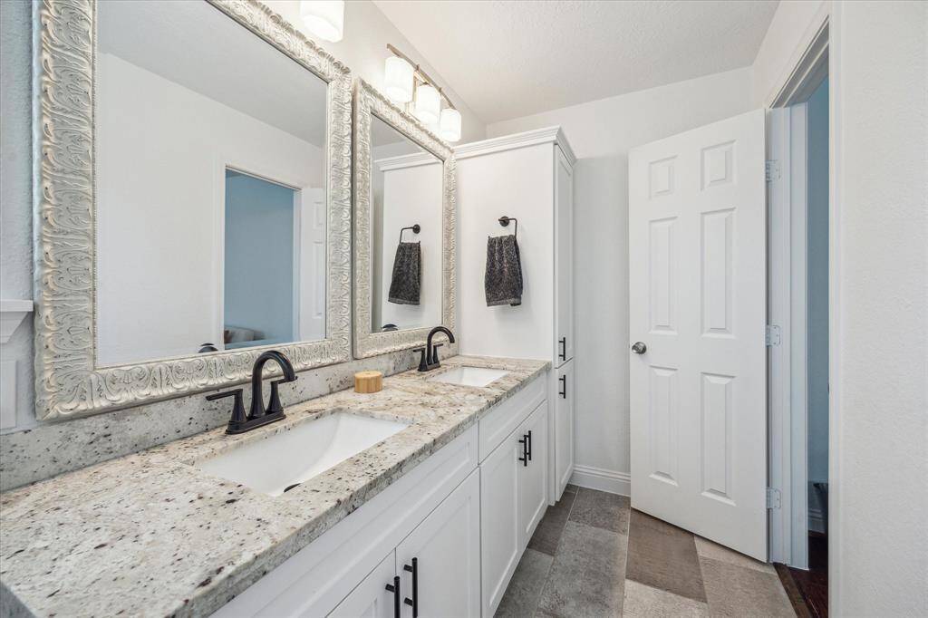 Primary bathroom view with shaker style cabinet doors, designer lighting and extra storage.