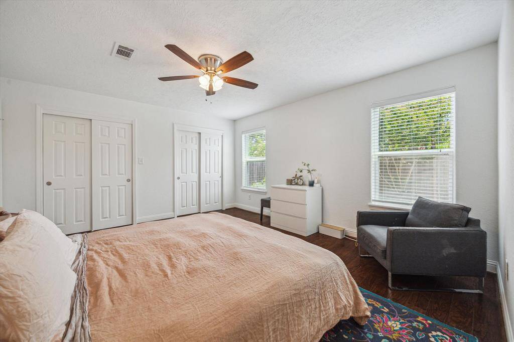 Primary bedroom view.  Engineered wood flooring, ceiling fan with a light + a wall of closets!
