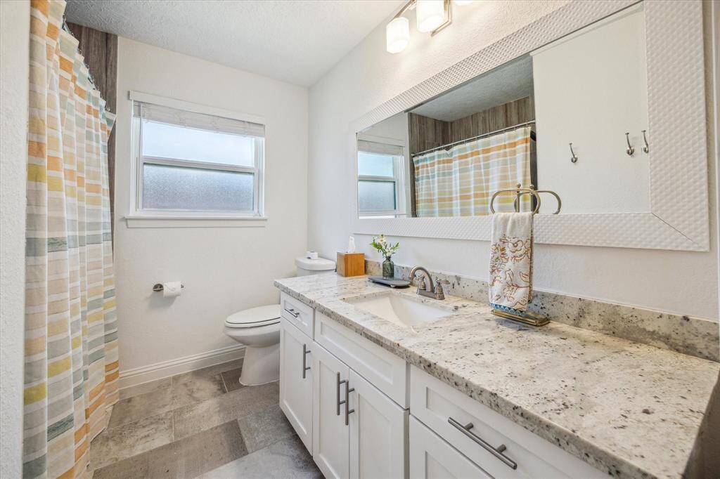 Guest full bathroom #2 with an oversized granite countertop vanity, brushed nickel hardware and faucet. Tub-shower great for kids.