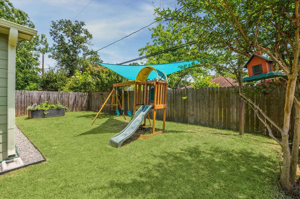 Back yard view. Children's play set can stay or be removed.  Black star rock has been placed around the entire home to help with drainage plus it looks great!