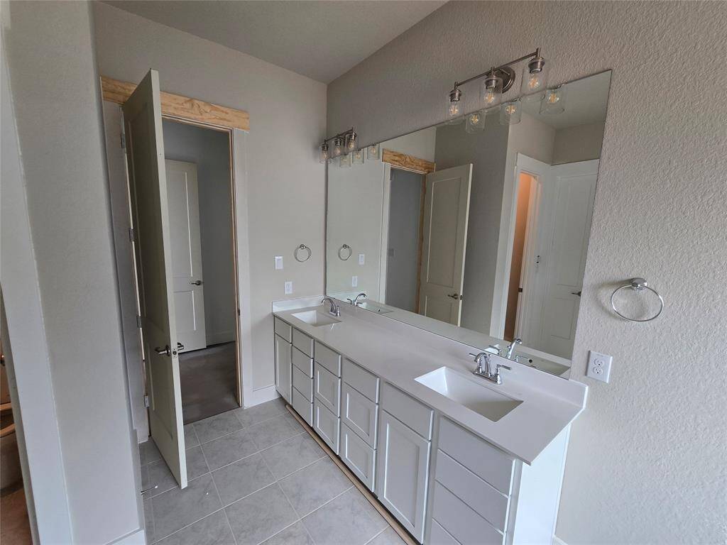 The soft glow of natural light filters through large windows, highlighting the elegant finishes – think polished countertops and luxurious tile work that catches your eye and invites you to linger.