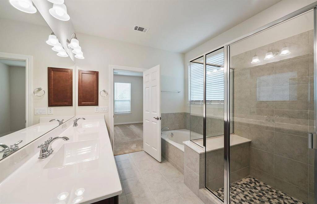Primary bathroom offers a seperate tub for relaxing and stand alone shower