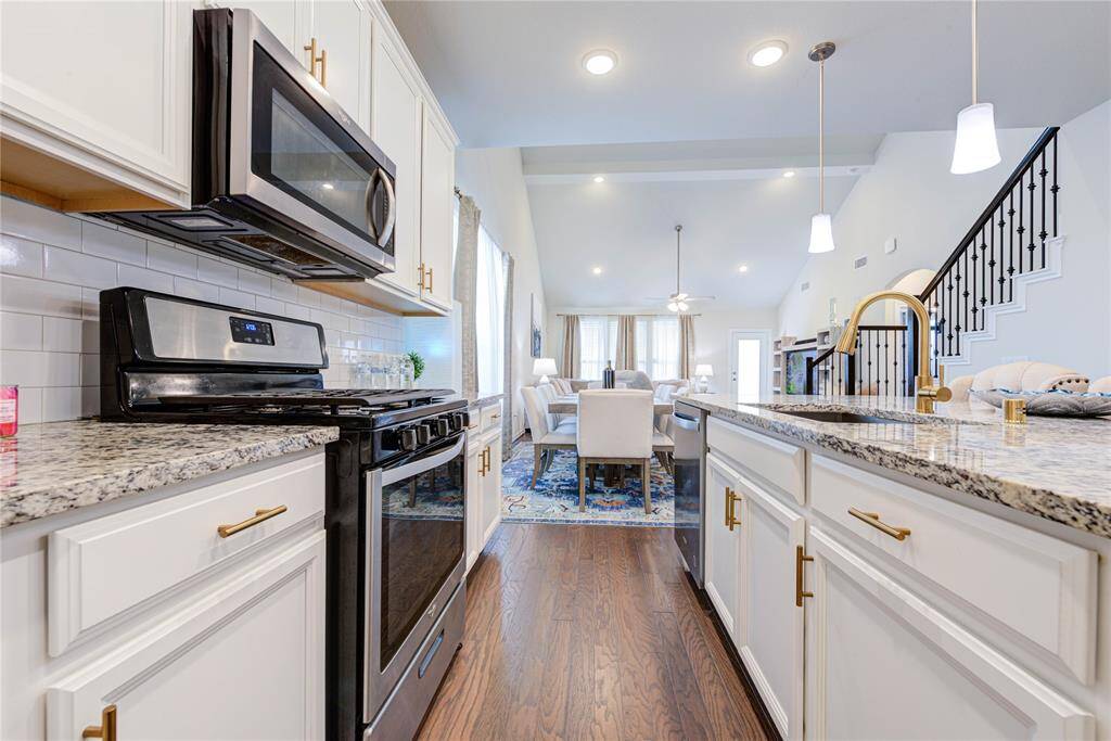 The kitchen is equipped with stainless steel appliances and white cabinetry, providing a bright and inviting atmosphere.