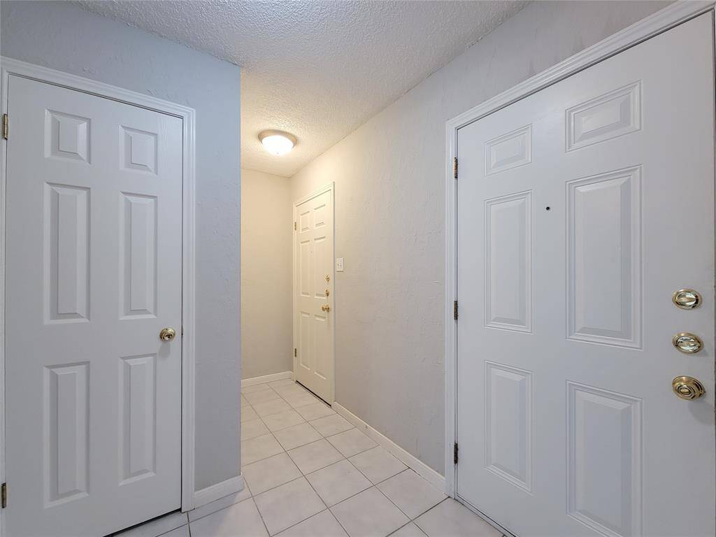 View of coat closet and garage access from entry way