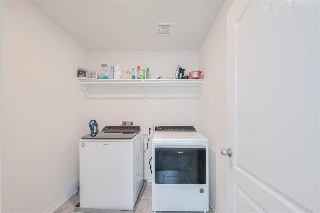 The perfectly sized laundry room with shelving and a clothing rod even has enough room for an ironing board.