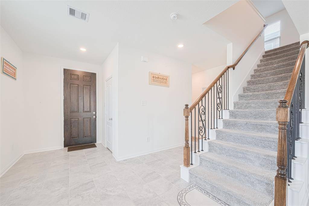 Once you enter the 8' Door you are greeted by 9' Ceilings, a Big Open Foyer and a Beautiful Wrought Iron Staircase.